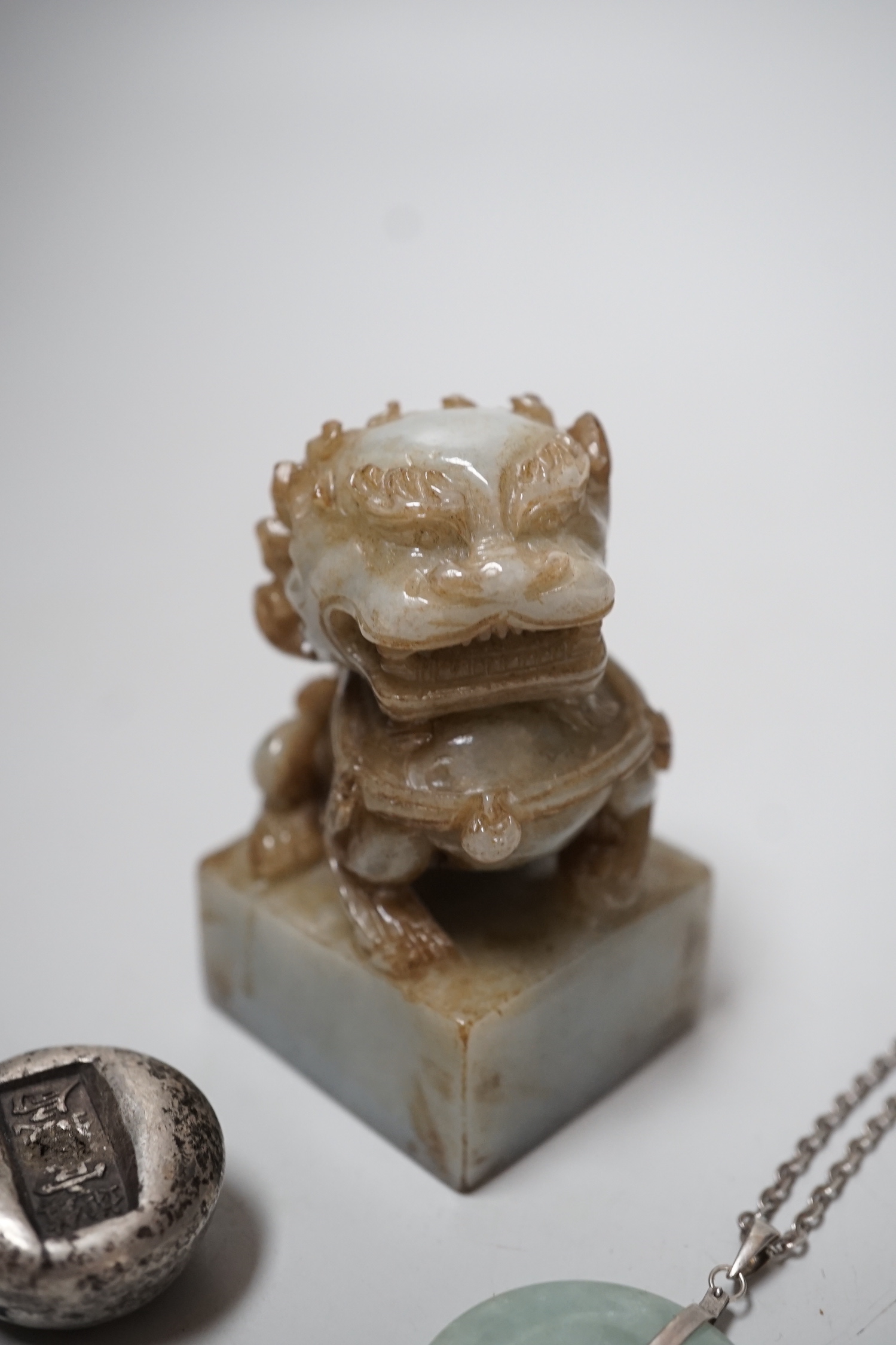 A Chinese jadeite lion-dog seal (black matrix), a similar pendant and two ingots